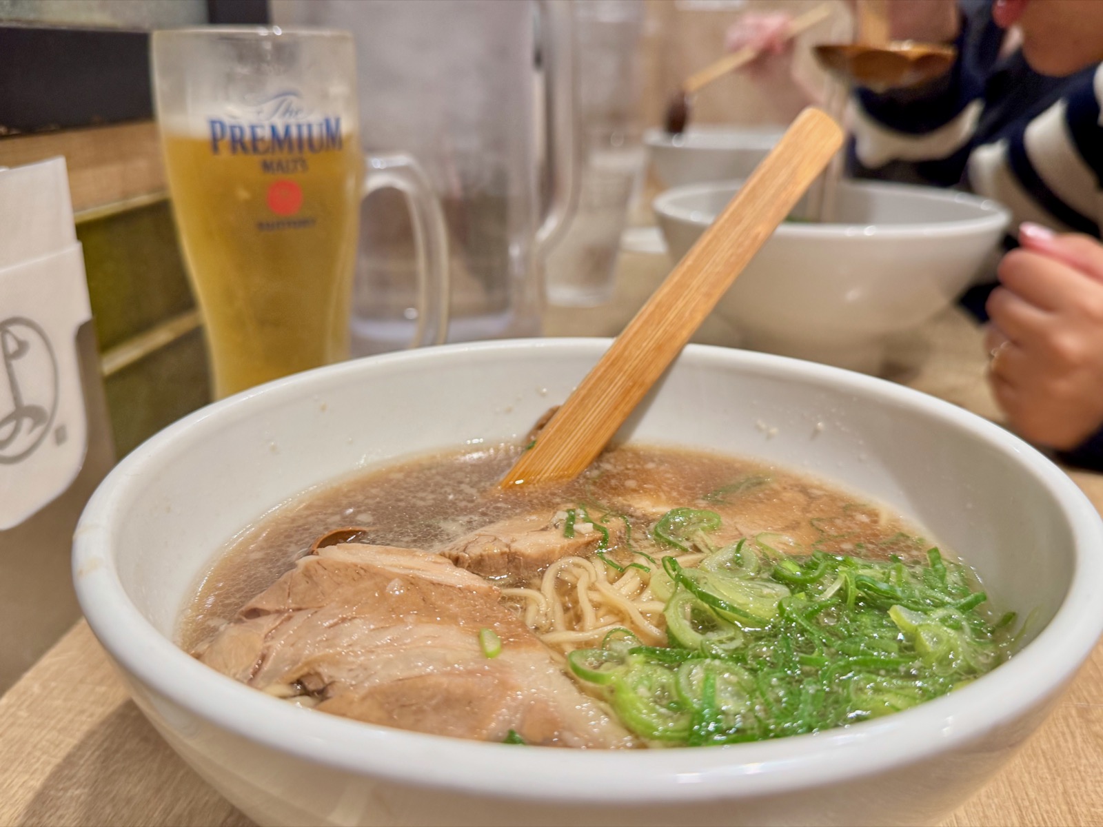 Kyoto-style ramen with chashu pork and green onions at Yottekoya, with a Premium Malts beer