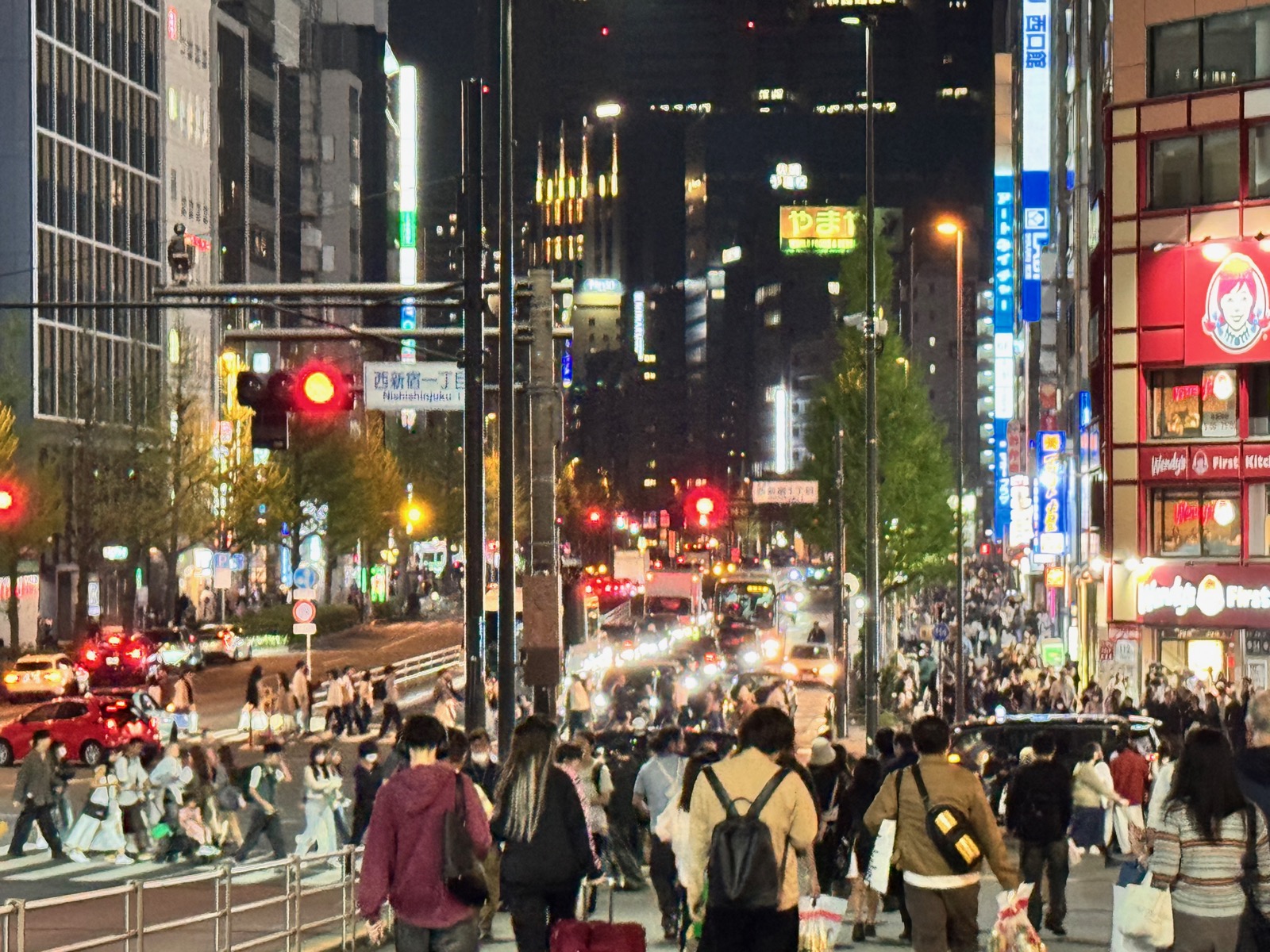 Shinjuku street at night, bustling crowds at a crosswalk with neon signs