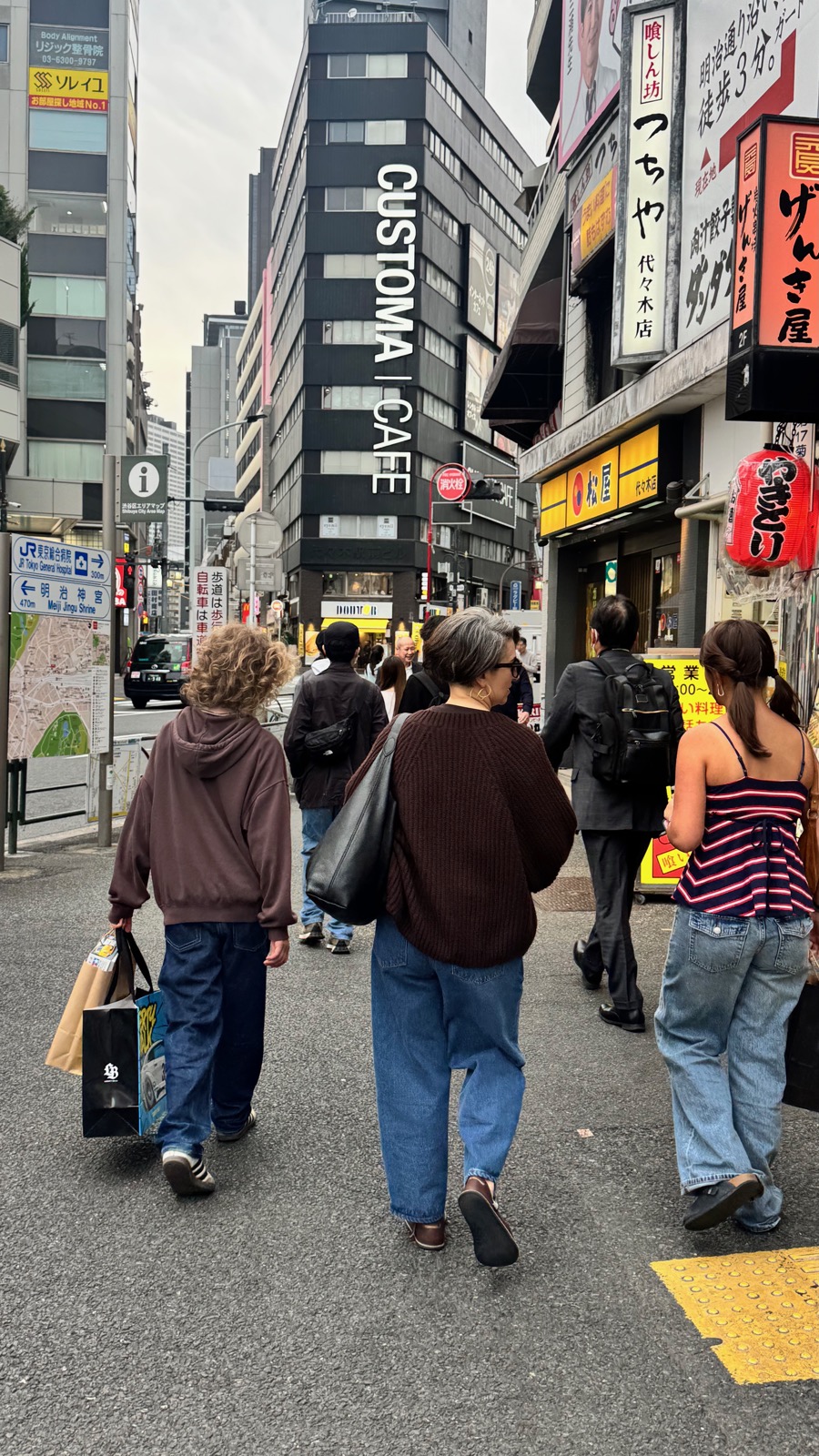 Family walking home through Shinjuku with shopping bags