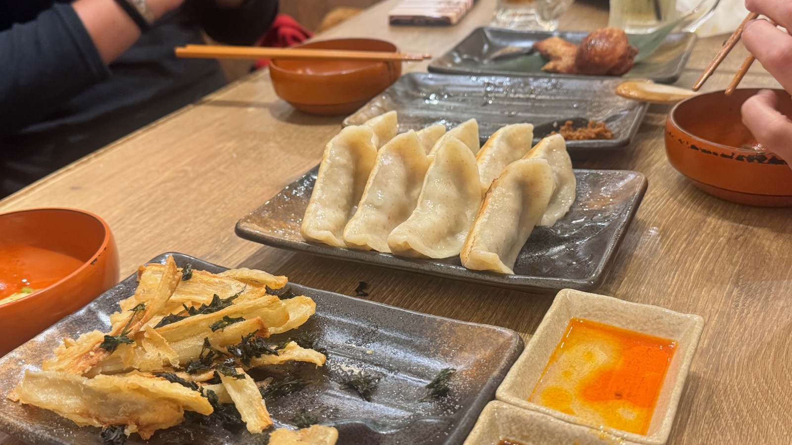 Dandadan Gyoza dinner spread — nikujiru gyoza, fried sides, and dipping sauces on the table