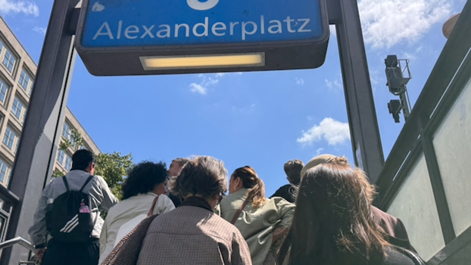 Climbing out of the U-Bahn under the Alexanderplatz sign into the sun