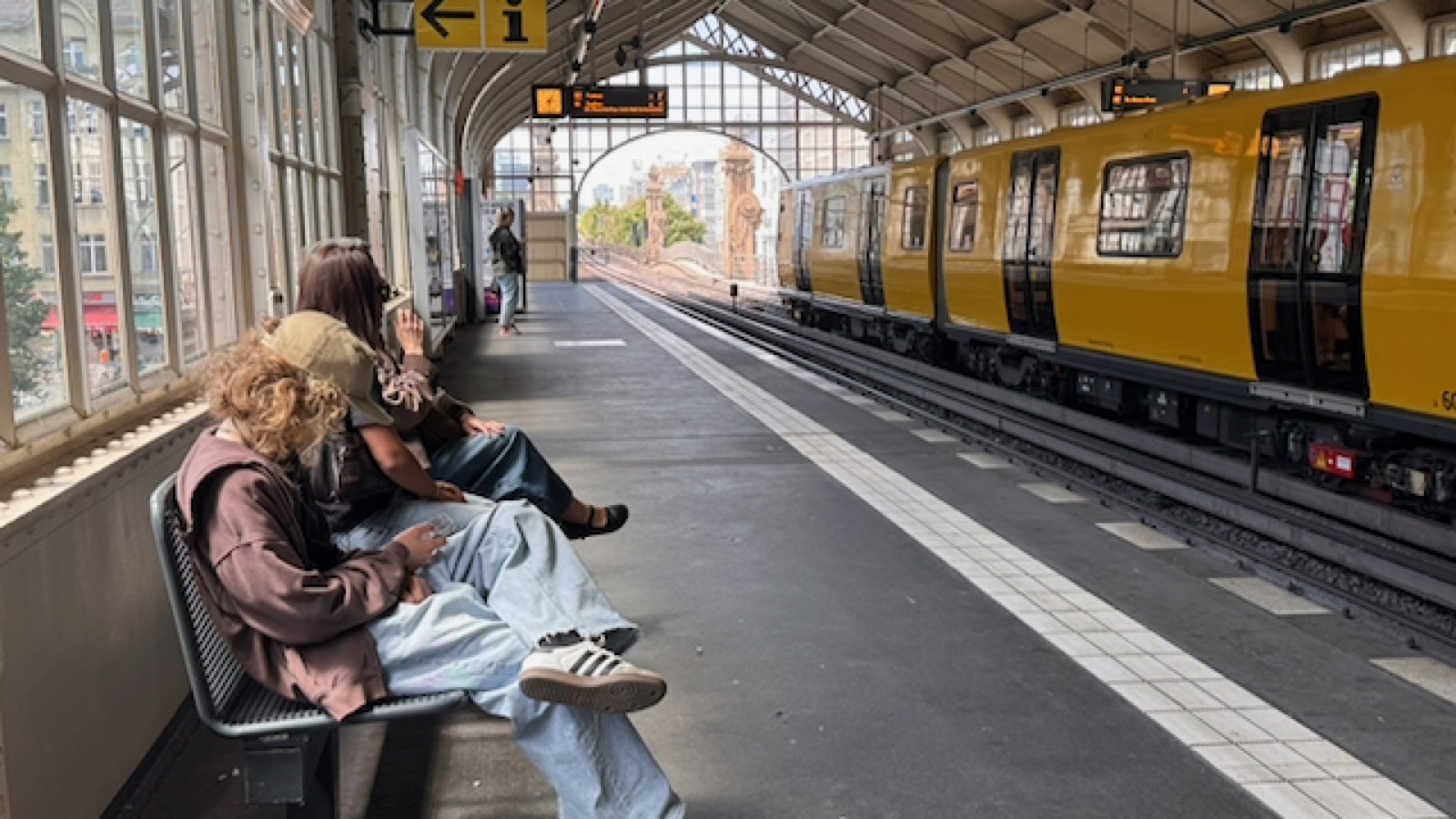 A yellow U2 train pulling into the iron-and-glass Bülowstraße elevated platform