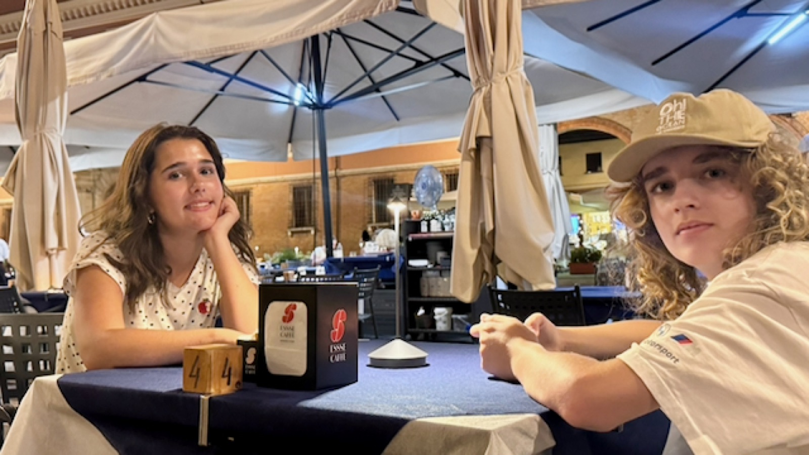 Phima and Luca at the first-night dinner table under the umbrellas in the centro